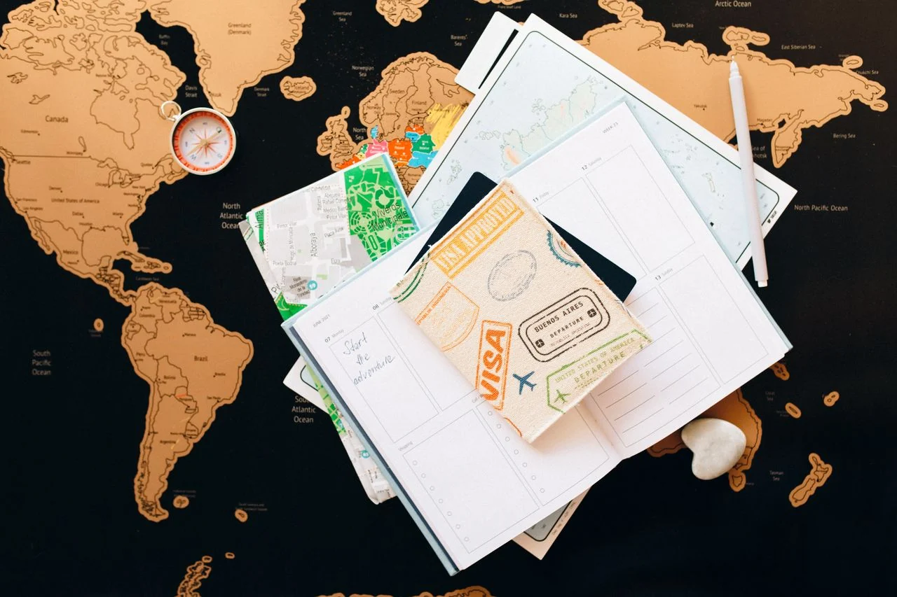 Notebook, compass and map for planning a personalised journey.