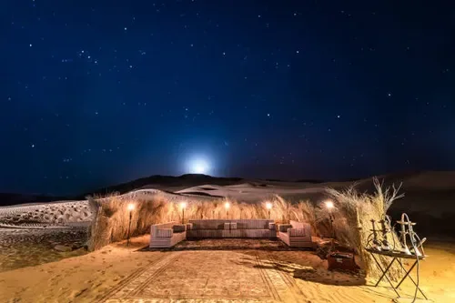 Sheltered tent at night in a desert setting; illustrative setting.