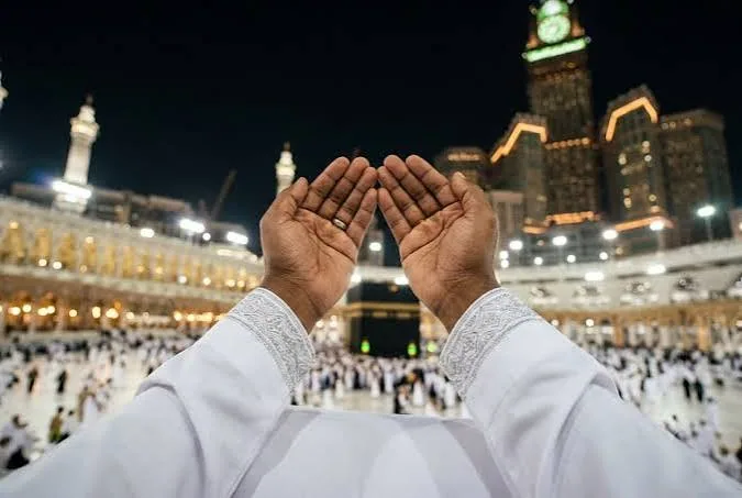 Hands raised in prayer near the Kaaba.